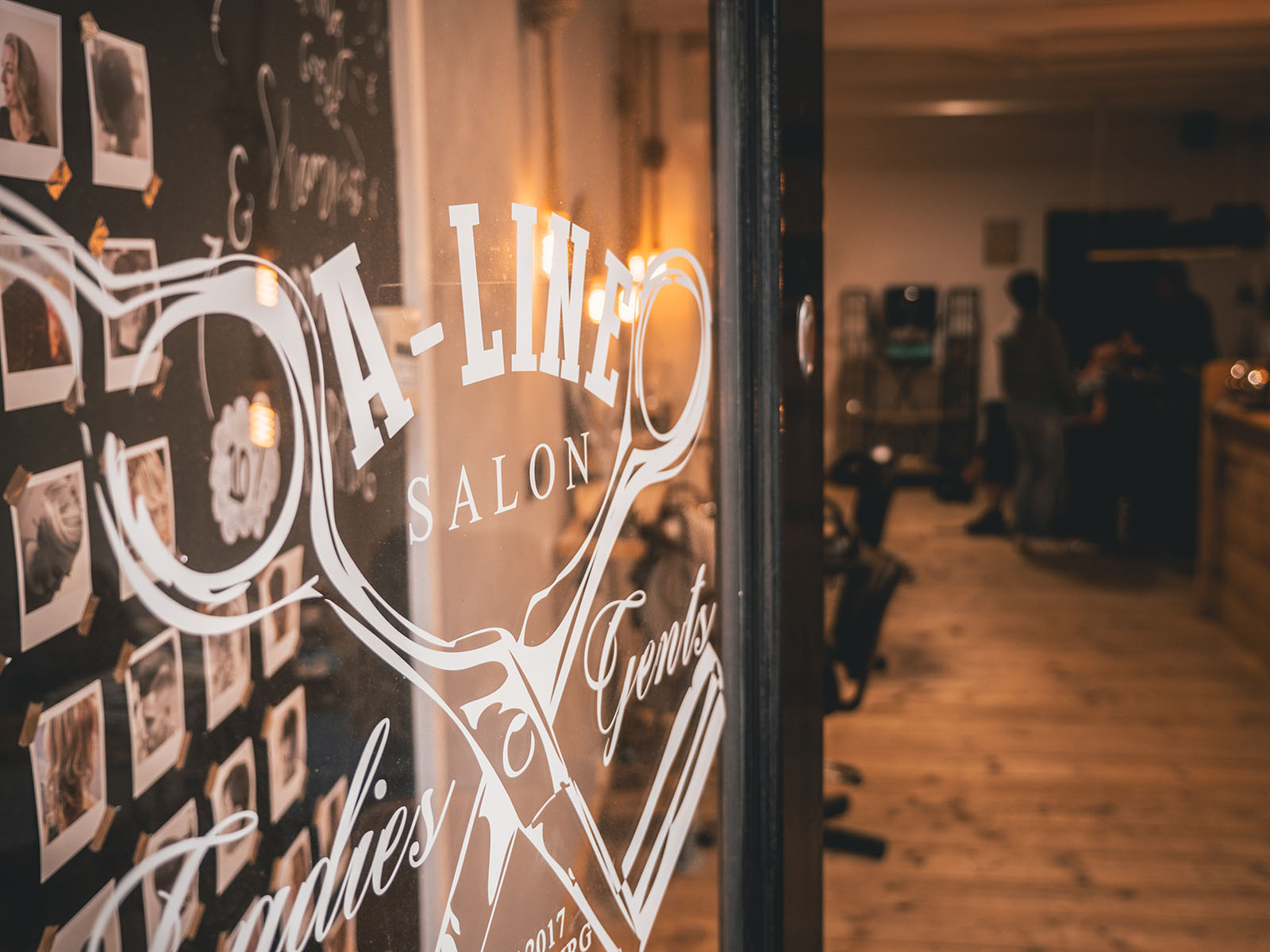 De warme entree van A-Line Salon met het logo op het raam